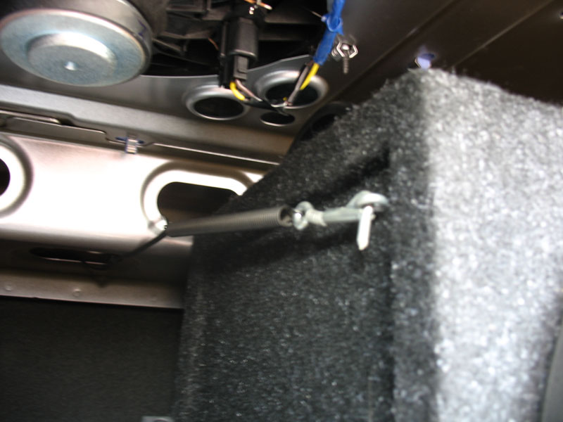 Sub box is locked in place with eye bolts in box, and spring-loaded locking hooks mounted to rear deck support rail with cable ties. Box can be easily removed, and hooks will attach to eye bolts in amp rack; allowing easy access to spare tire compartment.